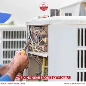 AC technician repairing a split unit in a Sports City Dubai apartment