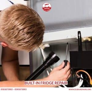 Built-in fridge with custom cabinetry panel being repaired in Dubai kitchen